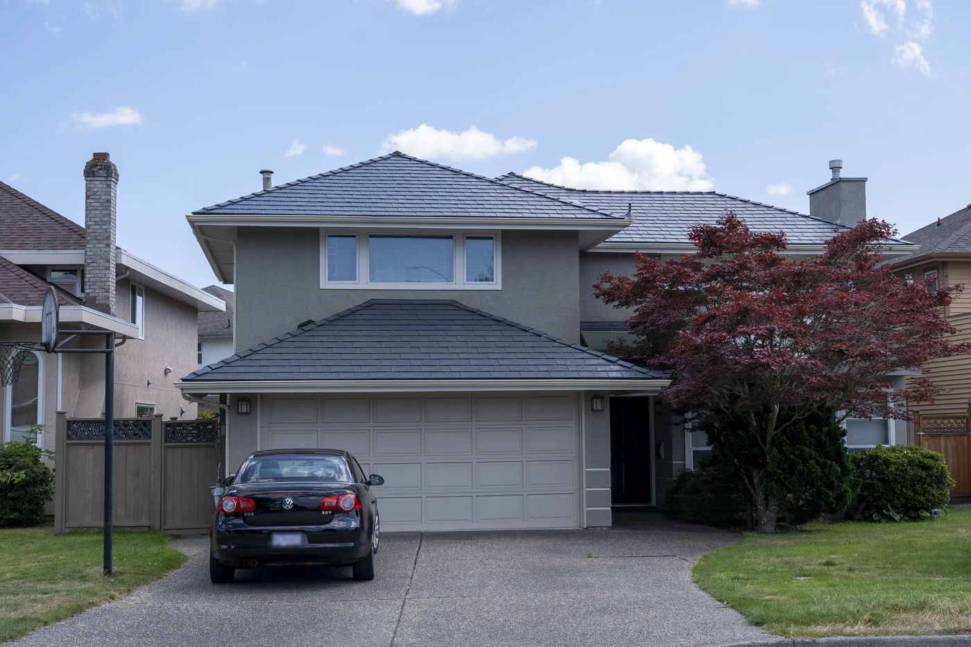 Deep Charcoal Interlock Slate aluminum roof on a two-storey home with grey siding and dormers in a, Richmond, British Columbia