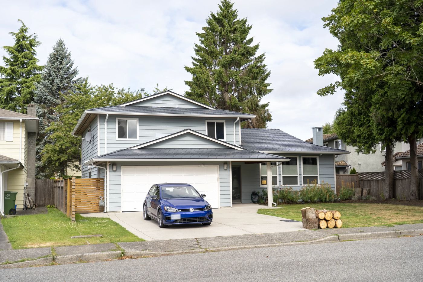 Deep Charcoal Interlock Slate aluminum roof on a two-storey home with a metal roof in a suburban forest, Richmond, British Columbia