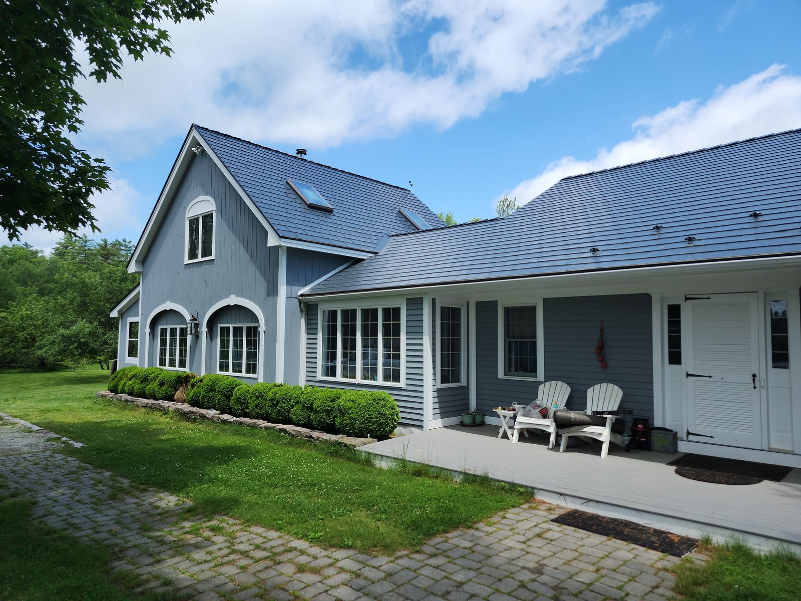 Deep Charcoal Interlock aluminum slate roof on a Craftsman home in Northwood, NH — Front-left elevation view