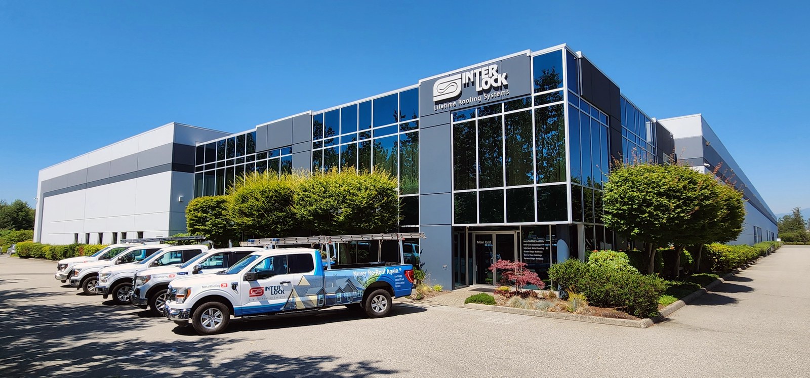 Interlock metal roofing facility in Delta, British Columbia, with branded company trucks