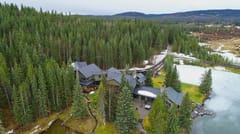 Black Interlock Shake aluminum roof on a two-storey home with dormers among tall pines, Bragg Creek, Alberta
