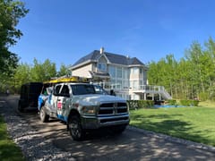 Black Interlock Cedar Shingle aluminum roof on a white two-storey home with a black metal roof in a wooded, Sherwood Park, Alberta