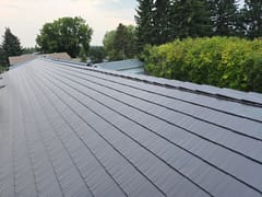 Tudor Brown Interlock Cedar Shingle aluminum roof on a Tudor brown metal roof on a single-family home among tall, Rocky Mountain House, Alberta