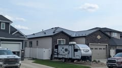 Black Interlock Slate aluminum roof on a black house with a metal roof in a rural area, Medicine Hat, Alberta