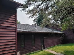 Musket Grey Interlock Shake aluminum roof on a brown ranch home with a grey metal roof in a rural setting, Warner, Alberta