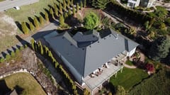 Deep Charcoal Interlock Slate aluminum roof on a two-storey home with dormers and a metal roof in a rural, West Kelowna, British Columbia