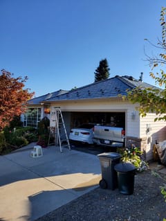 Deep Charcoal Interlock Slate aluminum roof on a white single-family home with a metal roof in a, West Kelowna, British Columbia