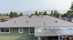 Taupe Interlock Slate aluminum roof on a taupe metal roof on a green ranch-style home in a, Delta, British Columbia