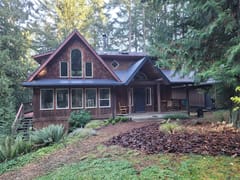 Deep Charcoal Interlock Slate aluminum roof on a brown A-Frame home with a metal roof in the forest, Gabriola Island, British Columbia
