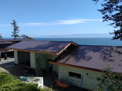 Tudor Brown Interlock Slate aluminum roof on a white single-family home with a Tudor brown metal roof, Shirley, British Columbia