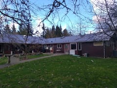 Tudor Brown Interlock Slate aluminum roof on a brown one-storey ranch home in a forest clearing, Duncan, British Columbia