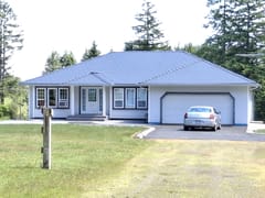 Deep Charcoal Interlock Slate aluminum roof on a light-coloured home with a metal roof in a coastal forest, Courtenay, British Columbia