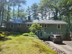 Charcoal Grey Interlock Shingle aluminum roof on a grey ranch style home with a metal roof in a wooded area, New Gloucester, Maine