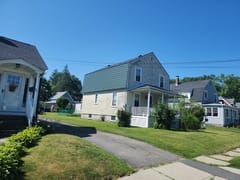 Hunter Green Interlock Slate aluminum roof on a two-storey house with a green metal roof in a suburban, Leominster, Massachusetts