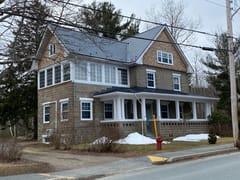Deep Charcoal Interlock Slate aluminum roof on a brown two-storey home with dormers on a snow-covered, Mahone Bay, Nova Scotia
