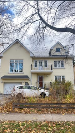 Front elevation of a 2-storey modern home in Etobicoke with deep charcoal standing seam metal roofing, dormers, and a second-floor balcony.
