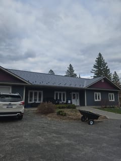 Front elevation of a single-storey ranch home in Sudbury, ON featuring Interlock deep charcoal cedar shingle aluminum metal roofing with snow guards.