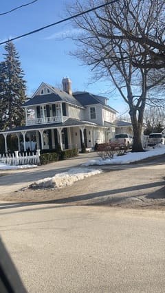 Victorian home in Collingwood ON with deep charcoal Interlock aluminum slate roof, wrap-around porch, dormers, and brick chimney in winter.