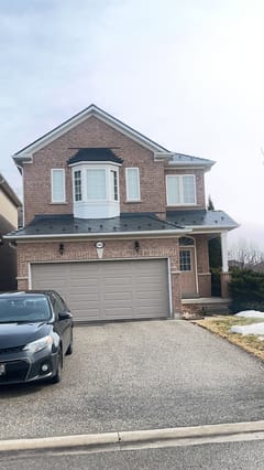 Two-storey brick home in Mississauga with Interlock deep charcoal aluminum slate metal roofing covering a multi-plane complex roof with bay window.