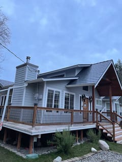 Craftsman home in Maple Valley, WA with deep charcoal Interlock aluminum slate metal roofing, featuring a complex multi-plane roof, chimney, and dormer above a wood-rail deck.