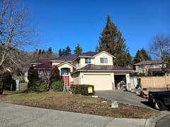 Two-story Craftsman home in Kirkland, WA with a Colonial Brown Interlock Mediterranean Tile metal roof featuring a complex multi-hip profile.