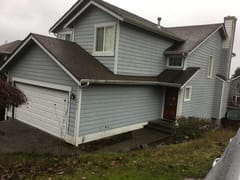 Deep Charcoal Interlock Slate aluminum roof on a grey two-storey home with dormers among tall pines, Silverdale, Washington
