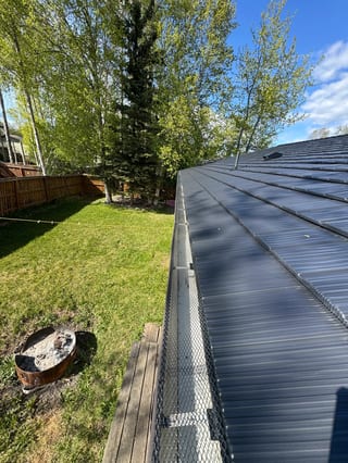 A black metal roof on a suburban home.
