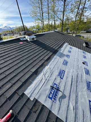 Black Interlock Shake aluminum roof being installed on the home, replacing a rotten asphalt shingle roof, Anchorage, Alaska