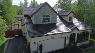 Metal roof with brown panels on a cream-colored Craftsman-style home