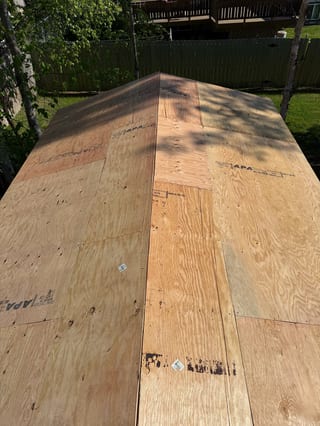 A new metal roof under construction in a rural setting.