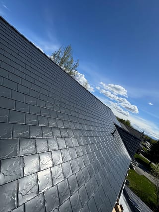 A modern metal roof with a sleek, silver finish and a contemporary home.