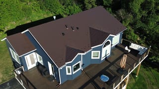 A modern house with a brown metal roof and white trim
