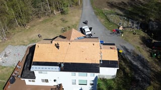 A modern single-family home with a partially installed metal roof