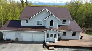 A modern style home with a brown metal roof and white siding