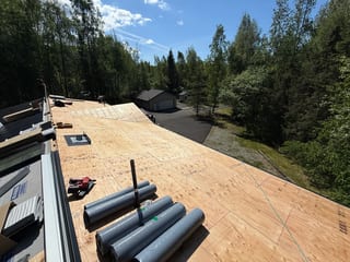 A metal roof under construction with a large section already covered in underlayment.