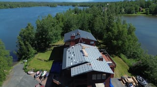 Aerial view of a finished metal roof with a lake in the background