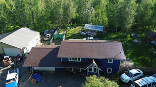 Modern home with dark blue siding and brown metal roof