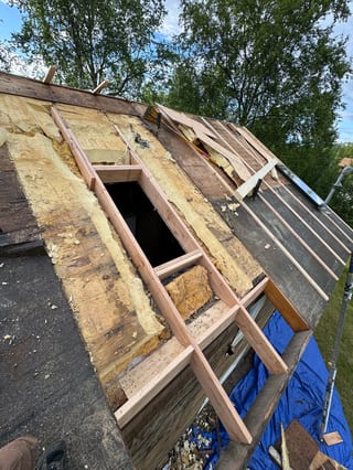 A modern metal roof on a single-family home in a rural setting.