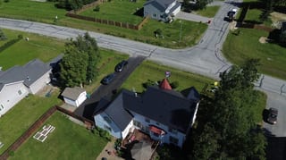 A white colonial home with a black metal roof