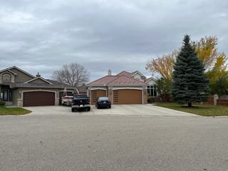 Aged Copper Interlock Shake aluminum roof on a beige one-storey home with a metal roof and attached, Calgary, Alberta