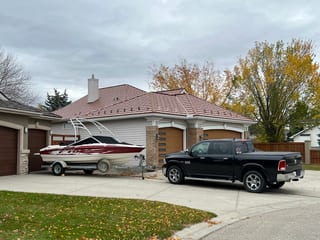Aged Copper Interlock Shake aluminum roof on a two-storey home with a metal roof and solar panels among, Calgary, Alberta