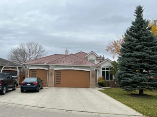 Aged Copper Interlock Shake aluminum roof on a white one-storey home with a metal roof in a suburban, Calgary, Alberta