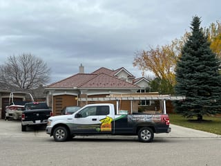 Aged Copper Interlock Shake aluminum roof on a house with a brown brick exterior and a red tile roof in, Calgary, Alberta