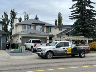 Charcoal Grey Interlock Slate aluminum roof on a white house with a metal roof in an urban setting, Calgary, Alberta