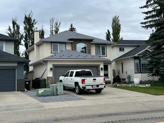 Charcoal Grey Interlock Slate aluminum roof on a beige two-storey home with dormers and a metal roof, Calgary, Alberta