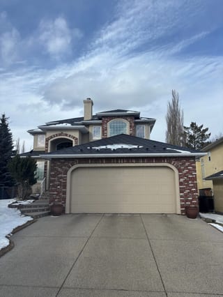 Black Interlock Slate aluminum roof on a two-storey home with a metal roof and brick accents in a, Calgary, Alberta