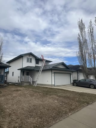 Hunter Green Interlock Slate aluminum roof being installed on a white two-storey house with dormers in a rural suburban, St. Albert, Alberta