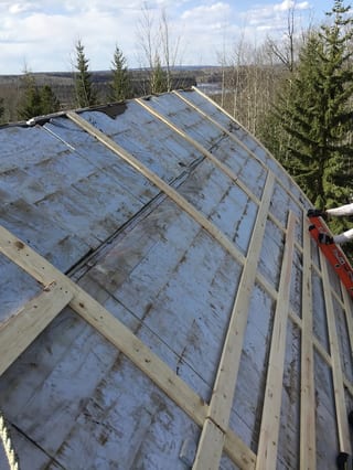 Black Interlock Slate aluminum roof on a metal roof on a home among tall trees, Whitecourt, Alberta