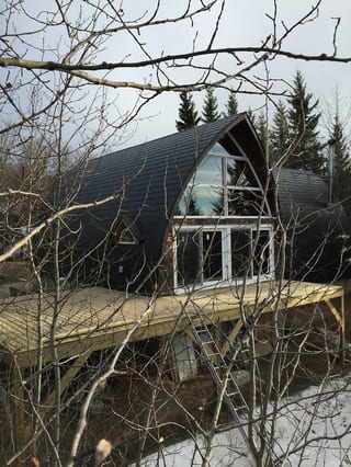 Black Interlock Slate aluminum roof on a black modern home with a metal roof among tall evergreens, Whitecourt, Alberta