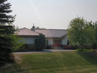 Weathered Interlock Shake aluminum roof on a white ranch home with a red door among tall trees, Sherwood Park, Alberta
